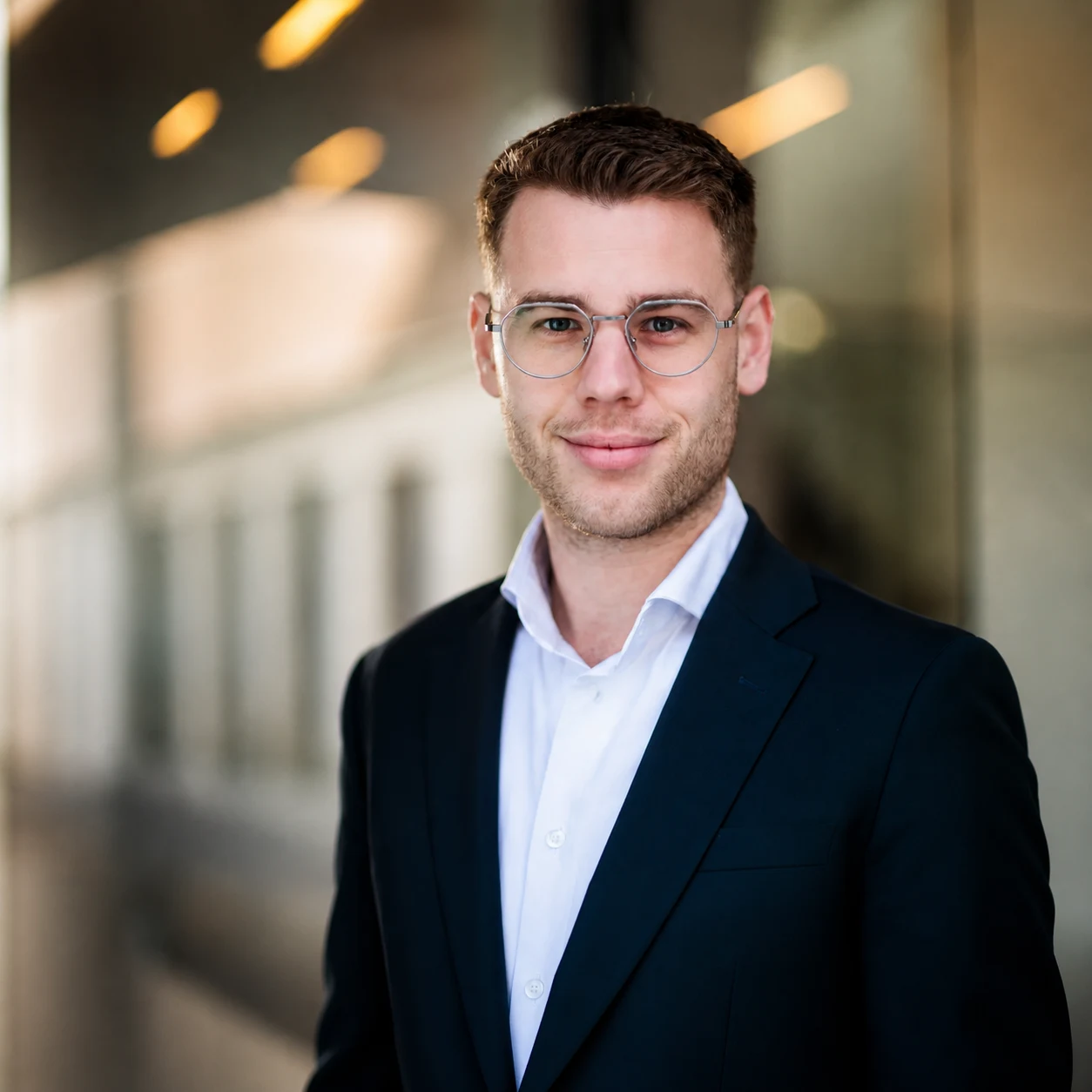 Portrait of Aljoscha Nickel in a suit and glasses