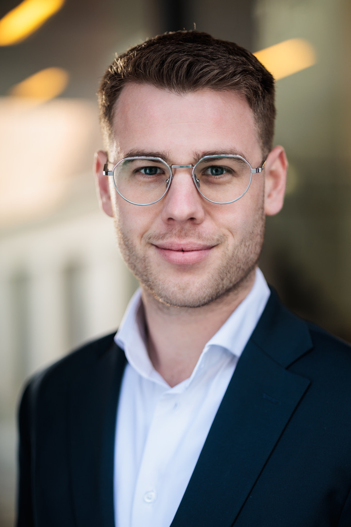 Porträt von Aljoscha Nickel im Anzug mit Brille